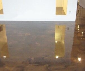 A room with a highly polished, reflective dark epoxy flooring Connecticut finish, showing shiny reflections of walls, lights, and doorways. The mirror-like effect under the ceiling lights highlights the quality typical of commercial kitchen flooring. A room with a highly polished, reflective dark epoxy flooring Connecticut finish, showing shiny reflections of walls, lights, and doorways. The mirror-like effect under the ceiling lights highlights the quality typical of commercial kitchen flooring.