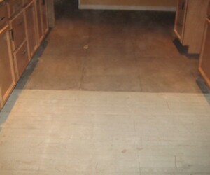 A kitchen floor with light-colored plywood subfloor partially exposed, showing a transition to a darker, unfinished section between rows of wooden cabinets, ideal for upgrading with USDA approved flooring. A kitchen floor with light-colored plywood subfloor partially exposed, showing a transition to a darker, unfinished section between rows of wooden cabinets, ideal for upgrading with USDA approved flooring.