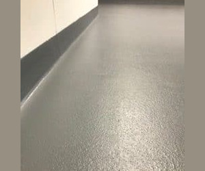 Textured gray epoxy flooring Connecticut with coved edges rises slightly up the white walls, creating a clean, seamless look ideal for commercial kitchen flooring in any indoor space. Textured gray epoxy flooring Connecticut with coved edges rises slightly up the white walls, creating a clean, seamless look ideal for commercial kitchen flooring in any indoor space.