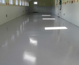 A clean, empty room with white speckled epoxy flooring Connecticut, white lower walls, small windows along the left wall, and bright sunlight streaming in through the windows. A clean, empty room with white speckled epoxy flooring Connecticut, white lower walls, small windows along the left wall, and bright sunlight streaming in through the windows.