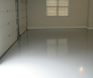 An empty garage with smooth, shiny gray resinous flooring CT, beige walls, two closed garage doors, and a window letting in natural light. An empty garage with smooth, shiny gray resinous flooring CT, beige walls, two closed garage doors, and a window letting in natural light.