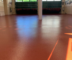 A photo of an empty, clean garage or fire station bay with shiny USDA approved flooring, bright natural light streaming through large windows and doors at the far end, and a single column in the center foreground. A photo of an empty, clean garage or fire station bay with shiny USDA approved flooring, bright natural light streaming through large windows and doors at the far end, and a single column in the center foreground.